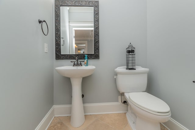 half bathroom featuring toilet, tile patterned flooring, and baseboards