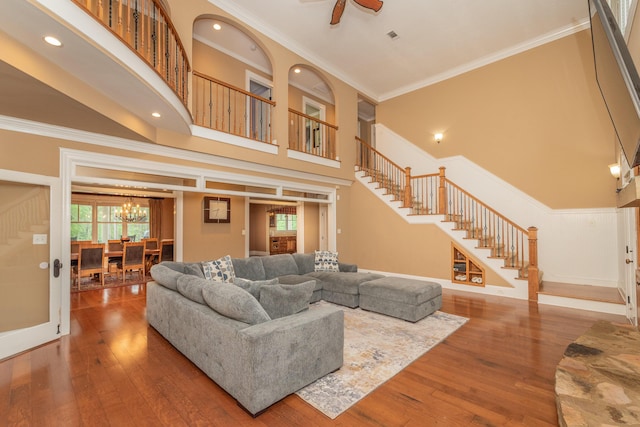 living area with a healthy amount of sunlight, stairs, and a towering ceiling
