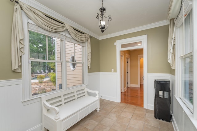 sitting room featuring a chandelier, wainscoting, and crown molding