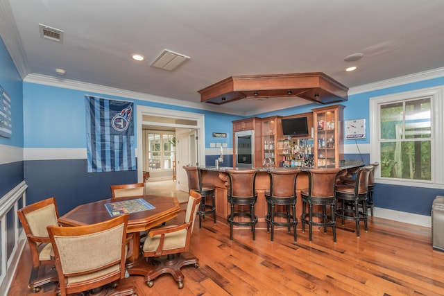 bar with visible vents, crown molding, and indoor bar