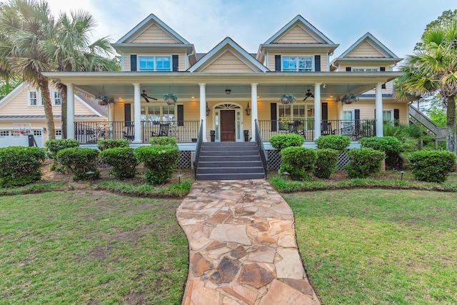 view of front of property featuring covered porch, ceiling fan, and a front yard