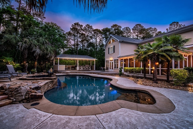 pool featuring a sunroom, a gazebo, an in ground hot tub, and a patio area