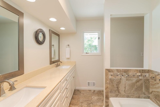 3411 Kamel Cir, Augusta, GA 30909 - bathroom with a garden tub, double vanity, baseboards, and recessed lighting