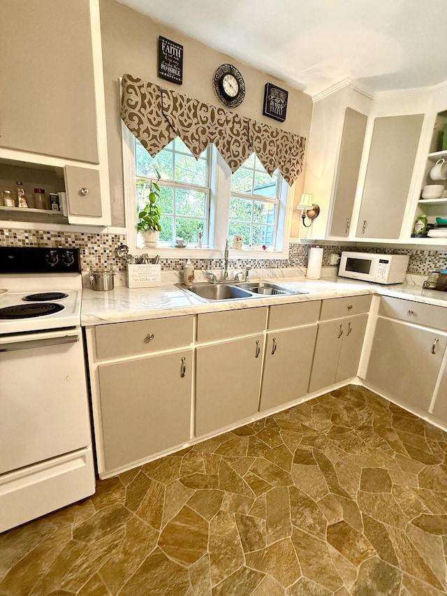 kitchen with white appliances, stone finish flooring, a sink, light countertops, and tasteful backsplash