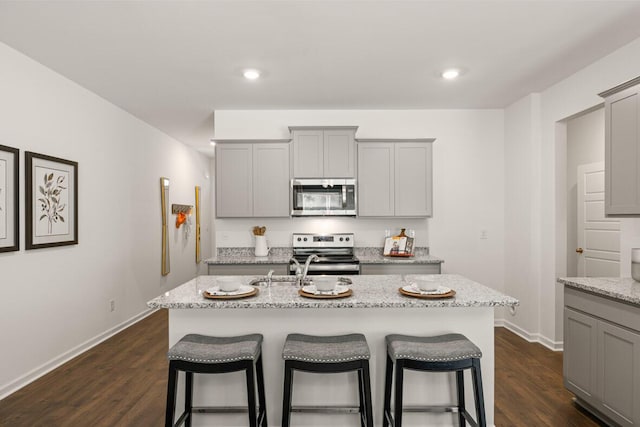 3445 Firestone Dr, Hephzibah, GA 30815 - kitchen featuring baseboards, gray cabinets, a breakfast bar area, and stainless steel appliances
