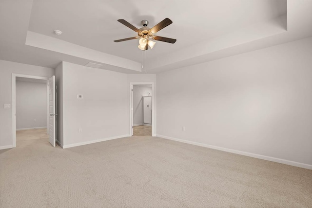 3445 Firestone Dr, Hephzibah, GA 30815 - unfurnished bedroom featuring baseboards, a ceiling fan, a tray ceiling, and light colored carpet