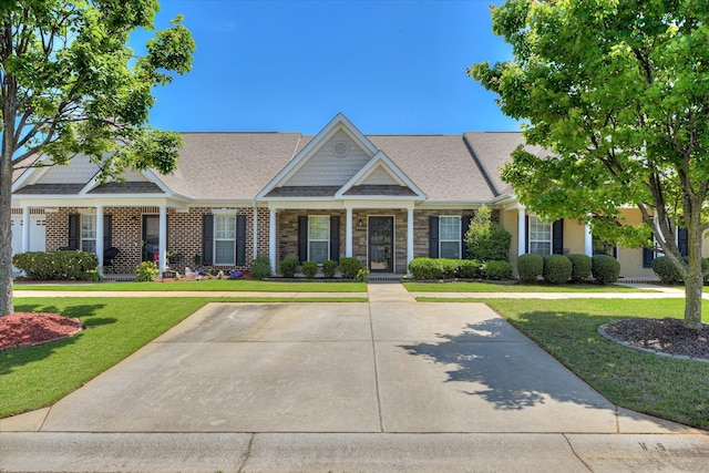 view of front of house featuring a front yard, a shingled roof, and a porch