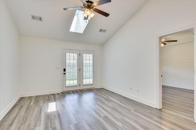 unfurnished room featuring a ceiling fan, wood finished floors, a skylight, baseboards, and high vaulted ceiling