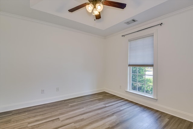 empty room featuring ceiling fan, wood finished floors, baseboards, and ornamental molding