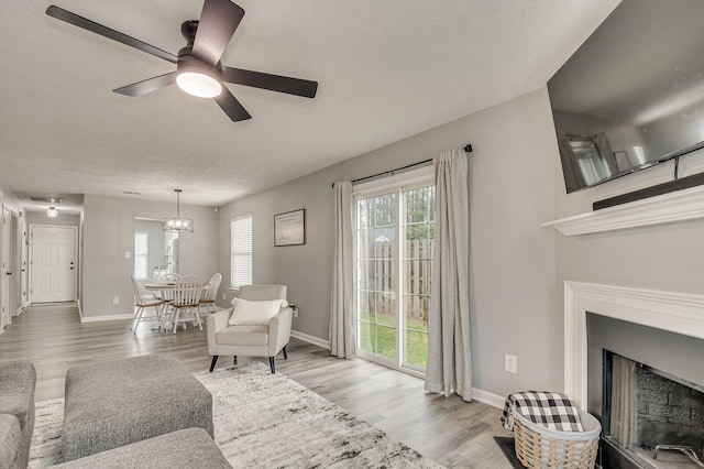 living area with a healthy amount of sunlight, a fireplace, and wood finished floors