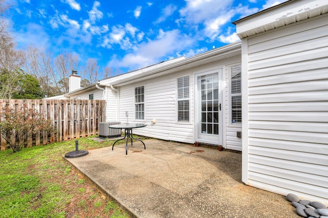 exterior space with central AC unit, fence, and a patio