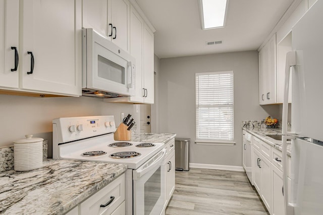 kitchen with white appliances, light wood finished floors, visible vents, baseboards, and white cabinetry