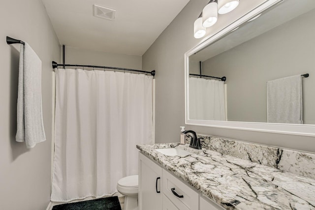 bathroom featuring toilet, vanity, visible vents, and a shower with curtain