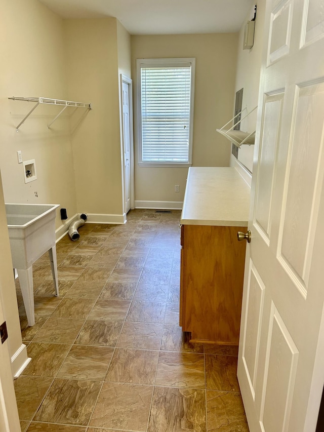 clothes washing area with washer hookup, baseboards, and laundry area