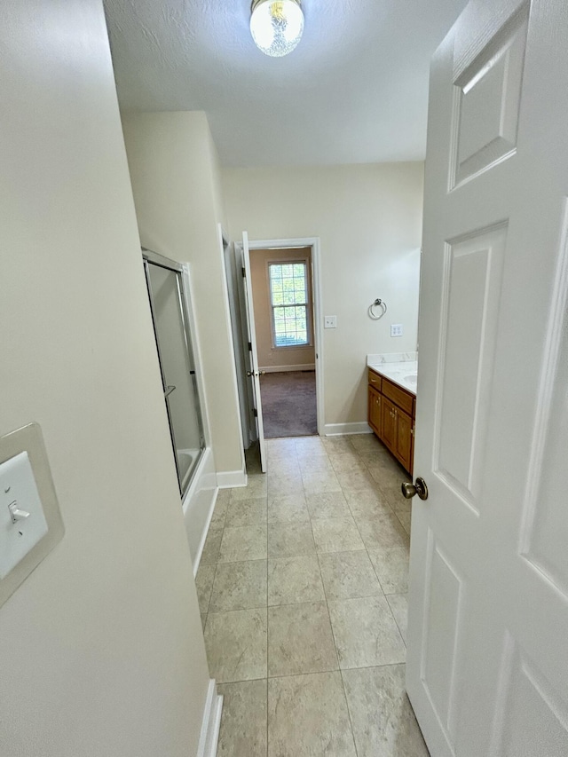 full bathroom featuring baseboards, combined bath / shower with glass door, tile patterned floors, and vanity