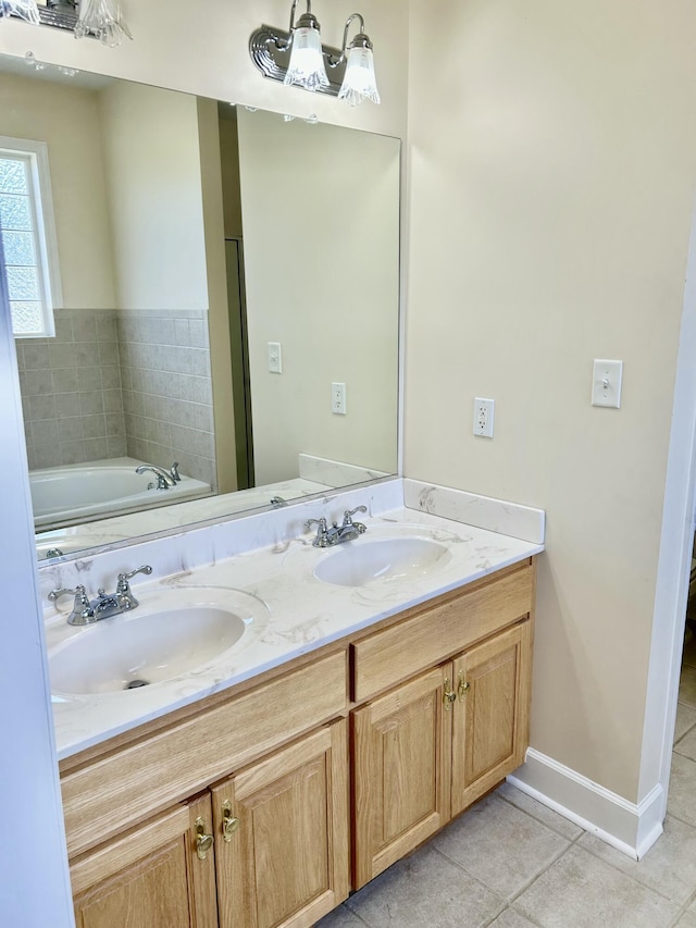 full bathroom featuring a sink, tile patterned floors, a garden tub, and double vanity