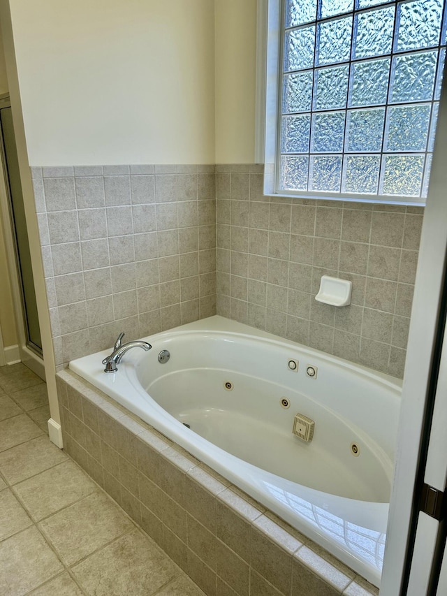 bathroom featuring tile patterned flooring and a tub with jets
