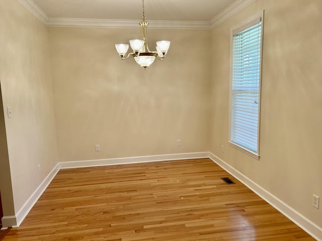 empty room with crown molding, a chandelier, and a healthy amount of sunlight