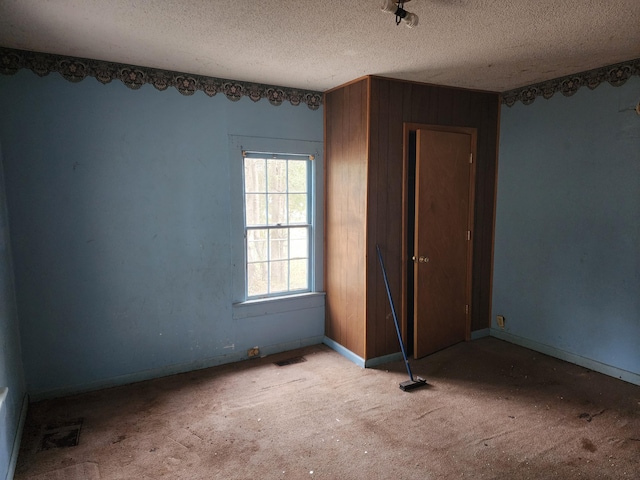 unfurnished bedroom with carpet flooring, baseboards, visible vents, and a textured ceiling