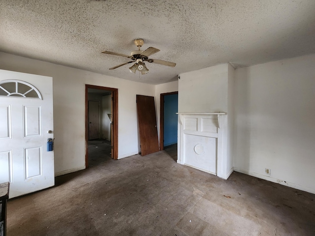 unfurnished bedroom with unfinished concrete flooring, a ceiling fan, baseboards, and a textured ceiling