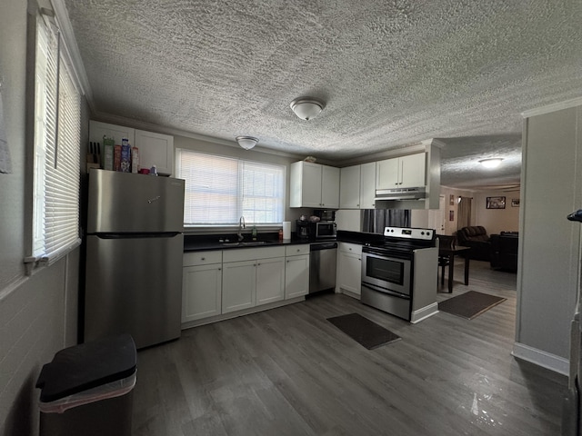 2402 Wheeless Rd, Augusta, GA 30906 - kitchen with stainless steel appliances, a textured ceiling, dark countertops, white cabinetry, and under cabinet range hood
