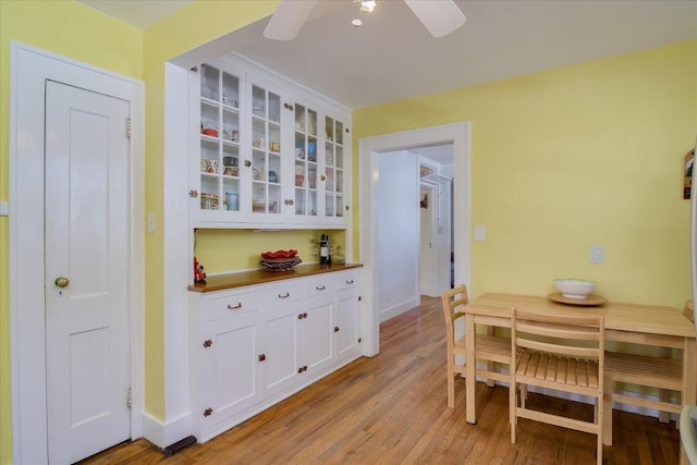 dining area featuring light wood-style floors, baseboards, and a ceiling fan