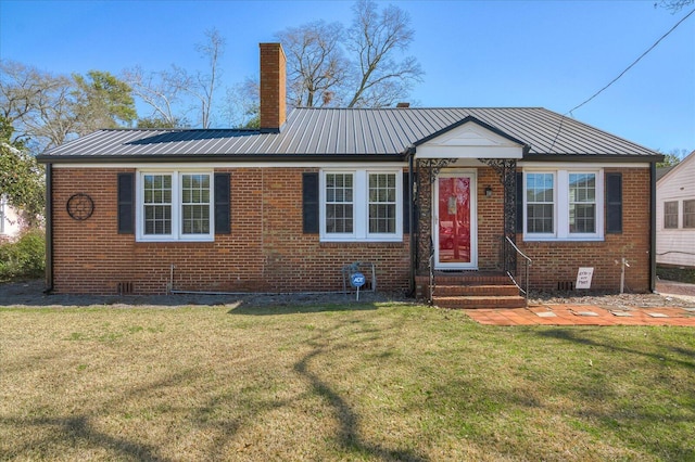 view of front of home with brick siding, a chimney, and a front lawn