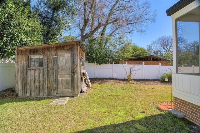 view of yard featuring fence private yard, an outbuilding, and a storage unit