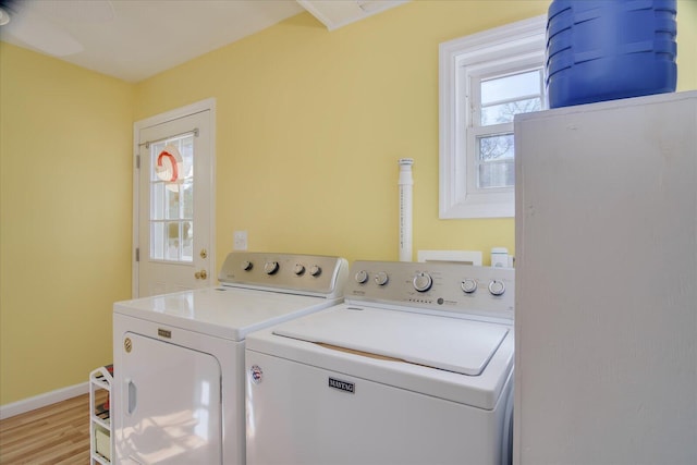 laundry room with a wealth of natural light, laundry area, washer and clothes dryer, and baseboards