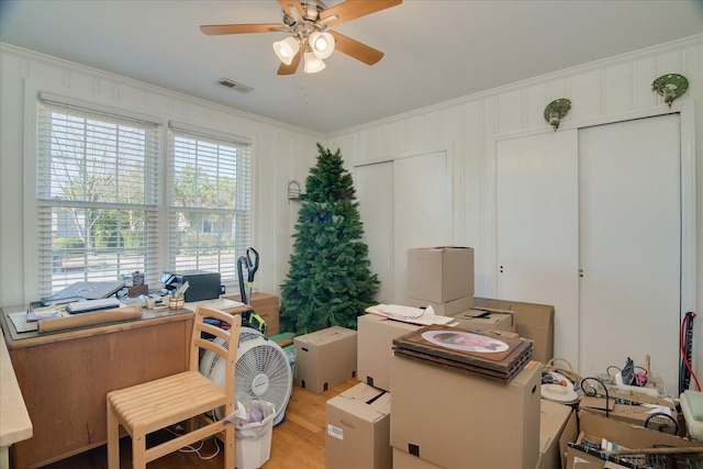 office space featuring ceiling fan, light wood-style floors, visible vents, and crown molding