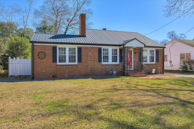 view of front facade with brick siding, metal roof, and a chimney