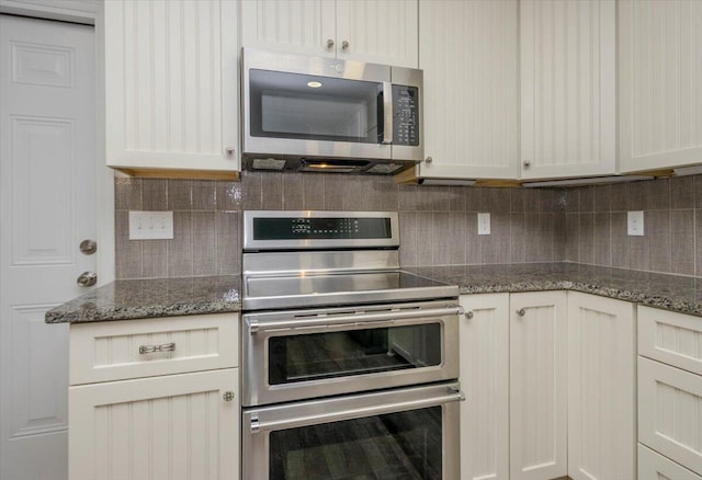 2924 Stratford Dr, Augusta, GA 30909 - kitchen featuring appliances with stainless steel finishes, tasteful backsplash, dark stone counters, and white cabinetry
