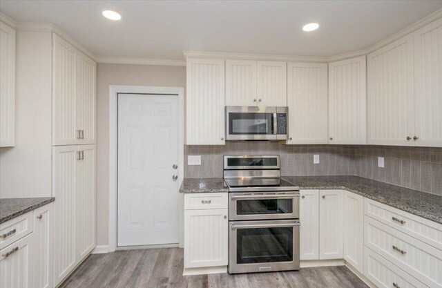2924 Stratford Dr, Augusta, GA 30909 - kitchen featuring stainless steel appliances, light wood finished floors, backsplash, crown molding, and stone counters