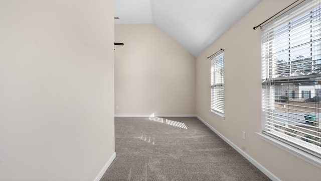 carpeted spare room with lofted ceiling