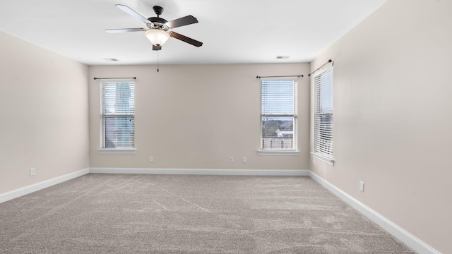 carpeted spare room featuring ceiling fan