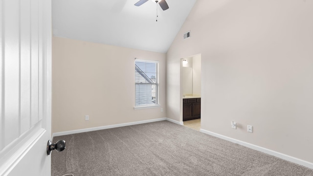 empty room with vaulted ceiling, ceiling fan, and light colored carpet