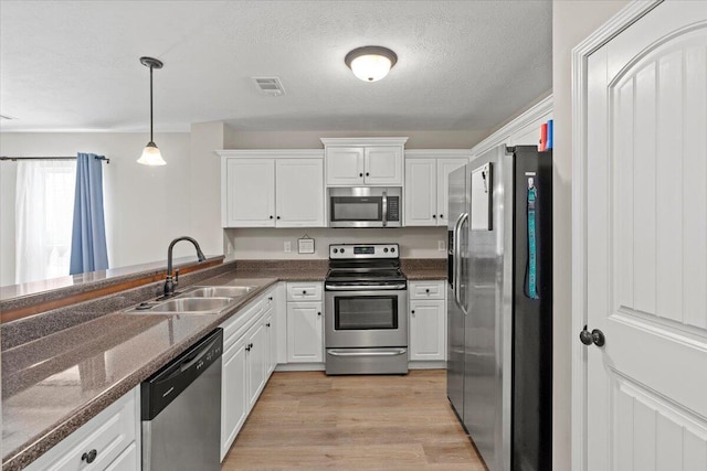 3382 Grove Landing Cir, Grovetown, GA 30813 - kitchen with stainless steel appliances, white cabinets, light wood finished floors, pendant lighting, and dark stone countertops