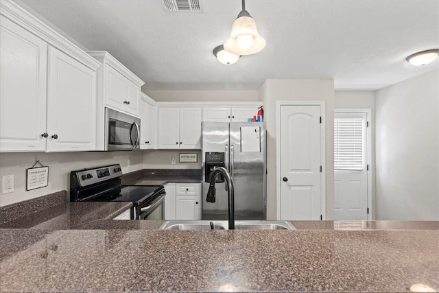 3382 Grove Landing Cir, Grovetown, GA 30813 - kitchen featuring stainless steel appliances, dark countertops, white cabinetry, a textured ceiling, and pendant lighting