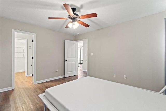 3382 Grove Landing Cir, Grovetown, GA 30813 - bedroom with wood finished floors, a walk in closet, and a ceiling fan