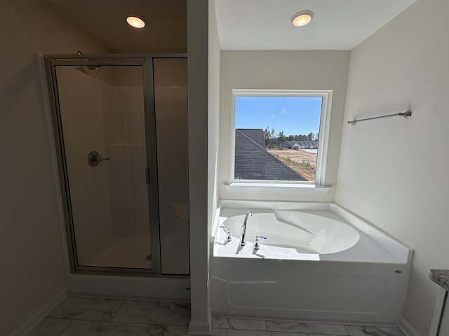 bathroom featuring baseboards, a garden tub, marble finish floor, and a shower stall