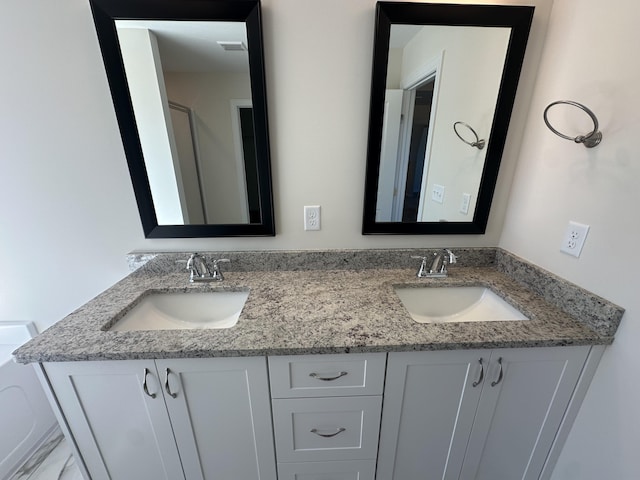 bathroom featuring double vanity, visible vents, and a sink