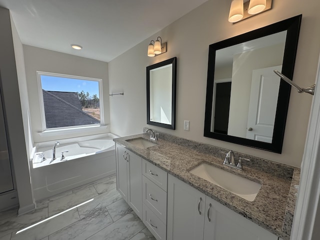 bathroom featuring a garden tub, double vanity, marble finish floor, and a sink