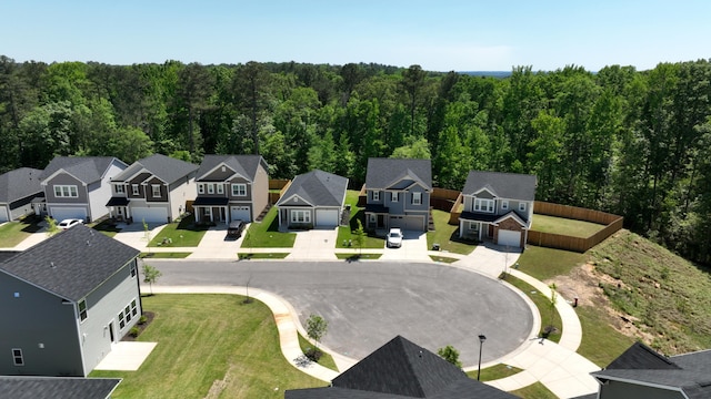 drone / aerial view featuring a forest view and a residential view