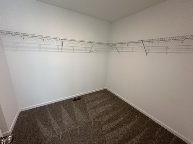 walk in closet with dark colored carpet and visible vents