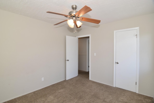 unfurnished bedroom featuring a textured ceiling, carpet floors, and ceiling fan