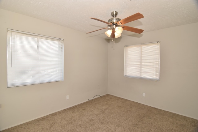 carpeted empty room featuring ceiling fan and a textured ceiling