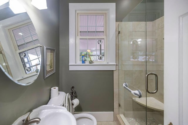 bathroom featuring sink, an enclosed shower, and toilet