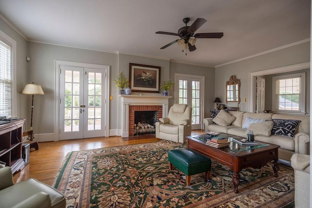 living room featuring ornamental molding, plenty of natural light, light hardwood / wood-style flooring, and french doors