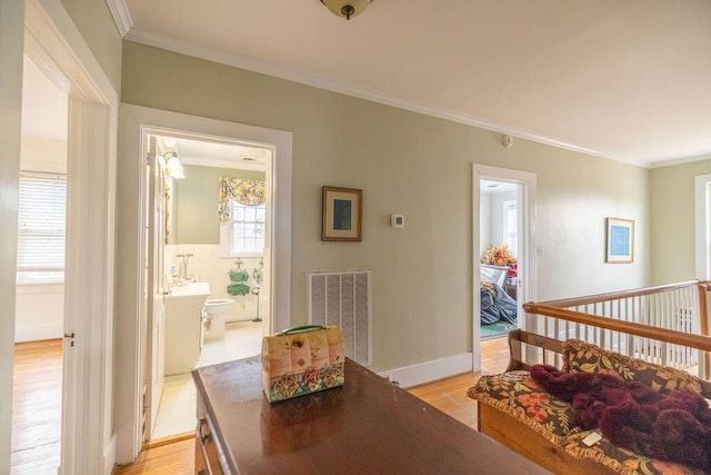 dining area with ornamental molding and light hardwood / wood-style floors