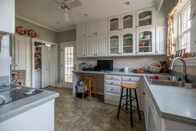 kitchen with backsplash, washer / dryer, sink, and white cabinets